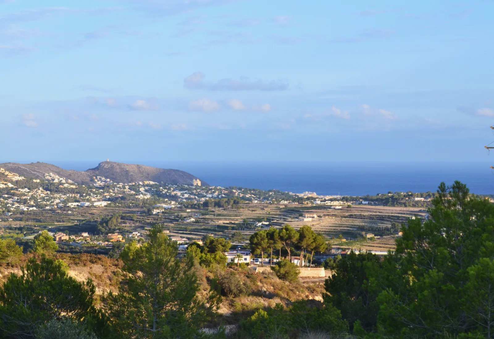 Ambiente de comercio y vida cotidiana en una calle de Moraira (imagen representativa: no es una fotografía literal del barrio)