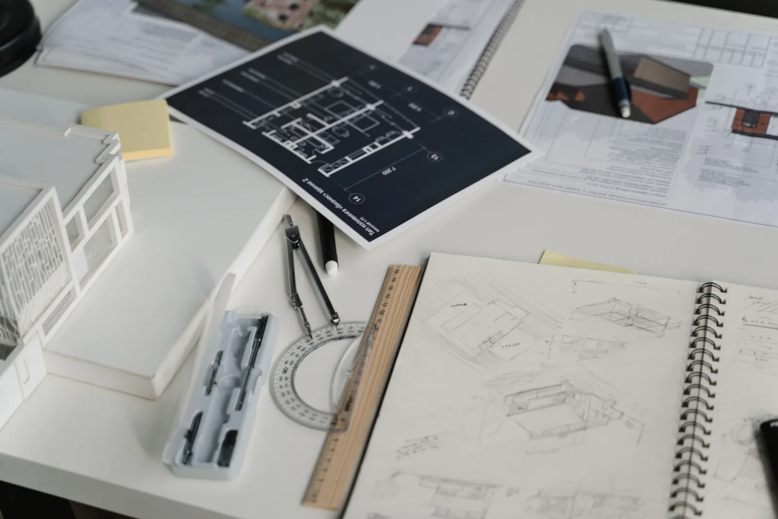 Mesa de trabajo de arquitectos con planos de vivienda unifamiliar durante el proyecto de una casa Passivhaus