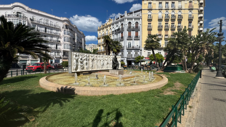 Fuente del Maestro Serrano rodeada de jardines y edificios en Gran Vía